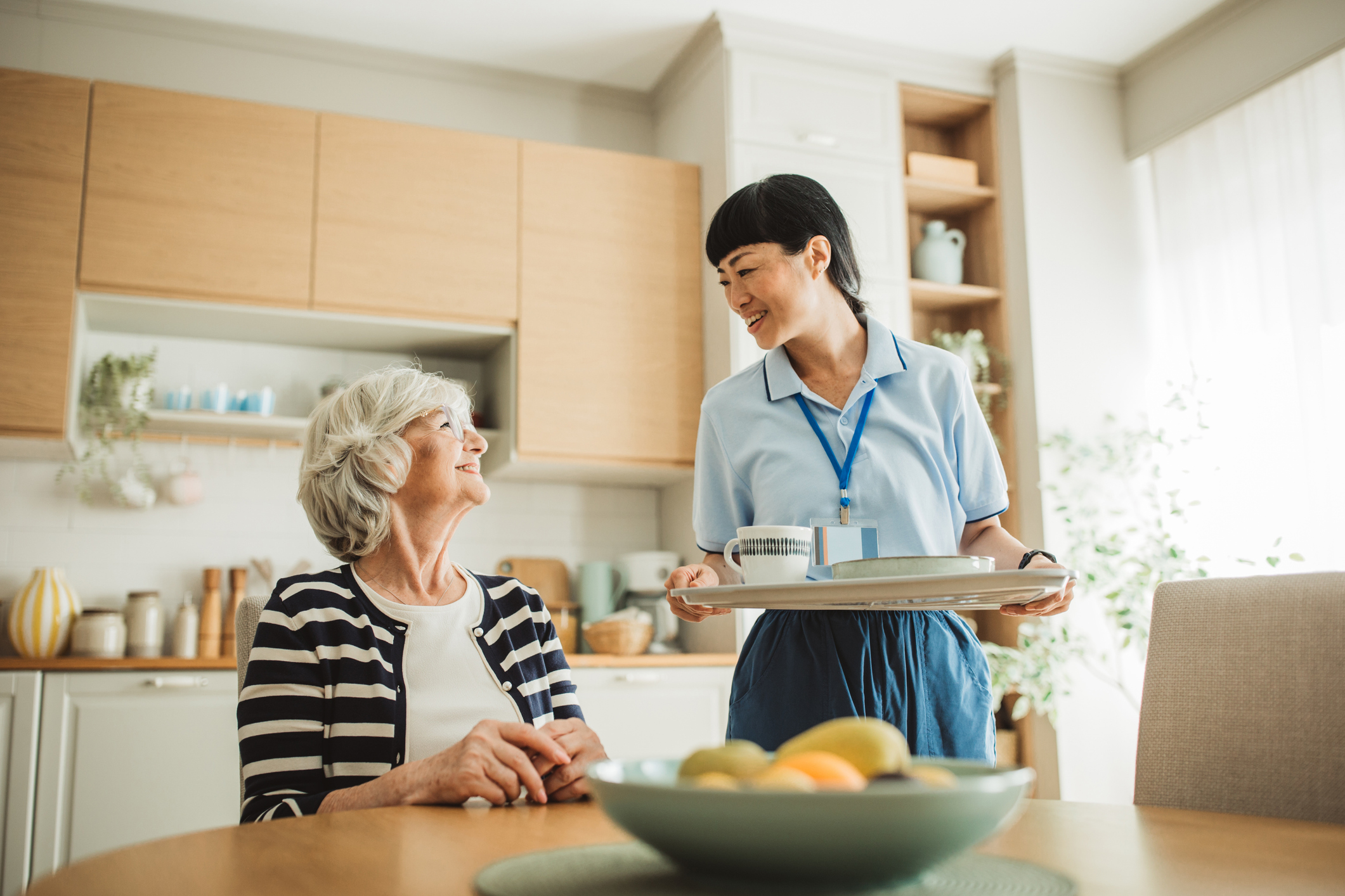A caregiver attentively listens to a patient, sharing laughter and connection in a delightful and supportive indoor environment.